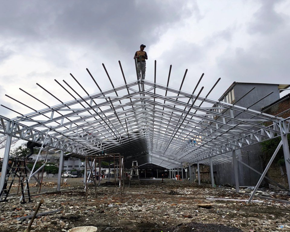 Rangka baja bentang lebar bangunan gudang yang sedang dipasang