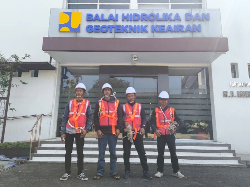 Tim proyek berseragam lengkap di depan gedung instansi pemerintah